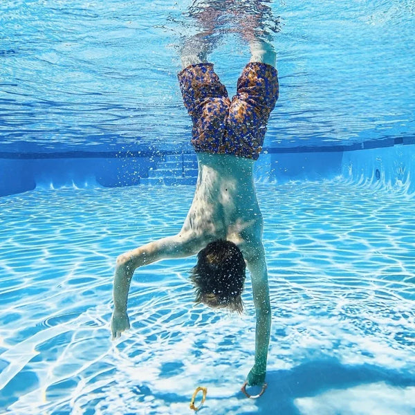 Child swimming underwater with diving rings