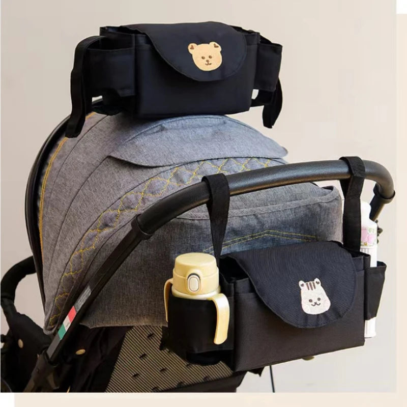 Black baby stroller organizer bag with cup holder on a pram