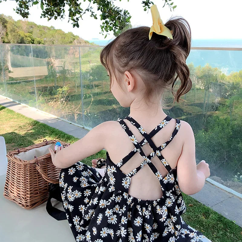 Girl wearing a black daisy print sleeveless slip dress
