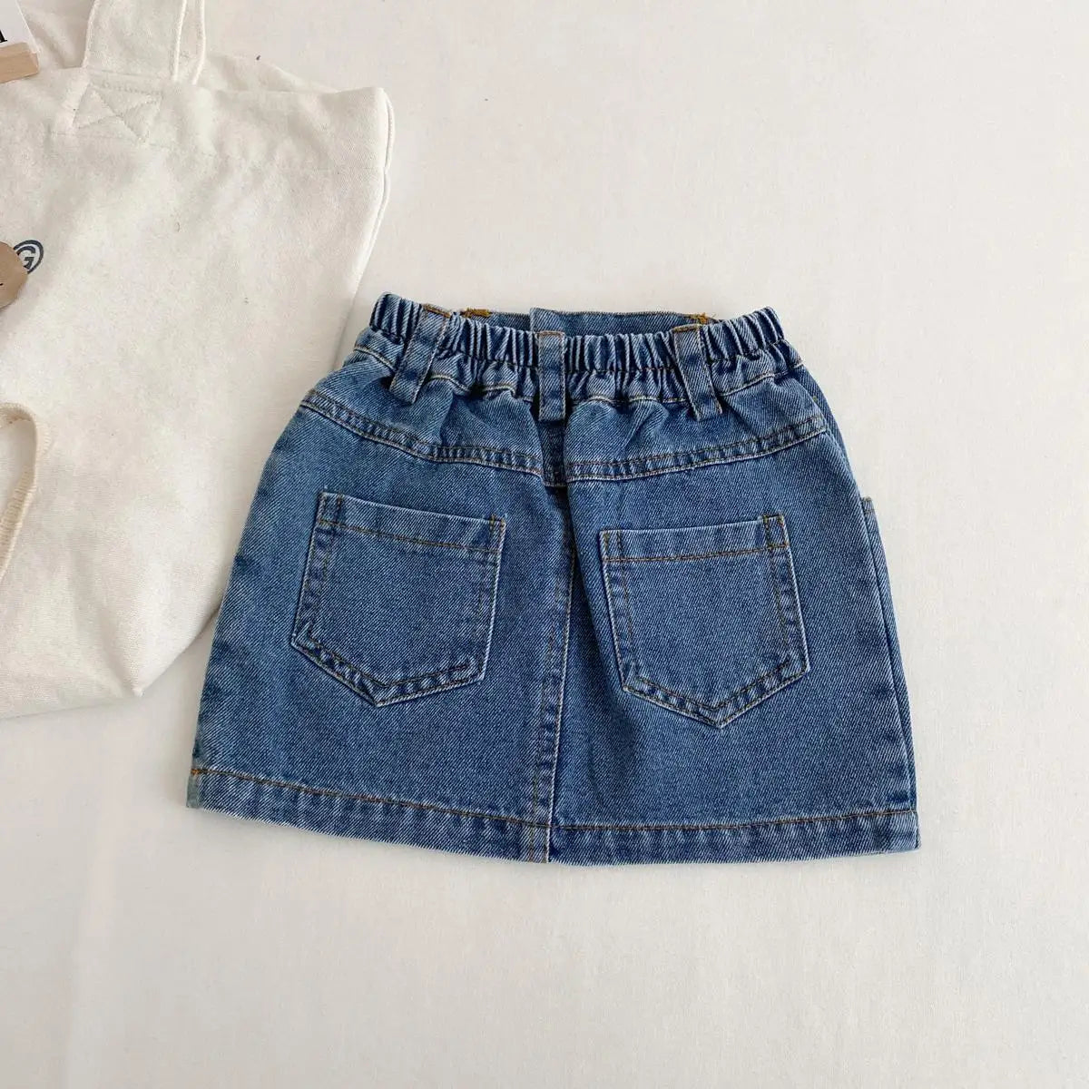 Girls cotton-denim skirt with pockets, back view — Kindle Kids ABC