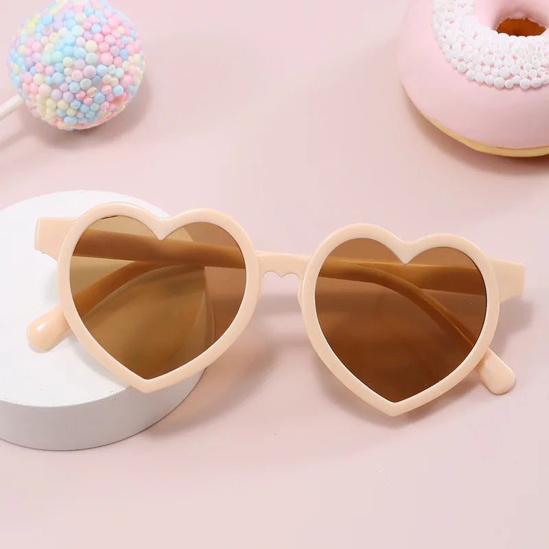 Beige heart-shaped kids sunglasses with candy props